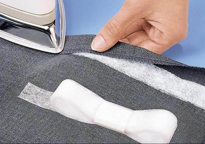 Iron pressing an adhesive web between textile layers